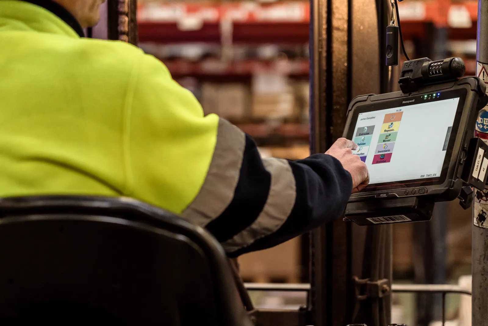 Operario de almacén usando la tablet de gestión de una carretilla